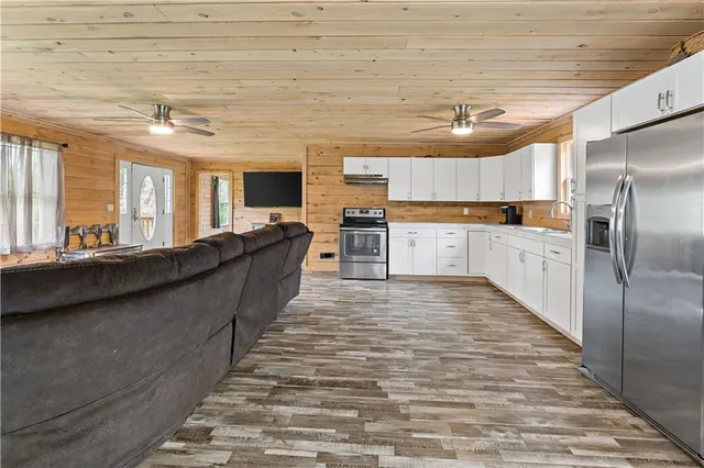 a large kitchen with kitchen island a large counter top space a sink stainless steel appliances and cabinets