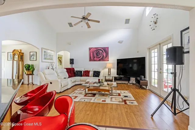 a living room with furniture flat screen tv and a view of kitchen