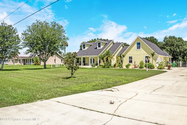 a view of house with yard and green space