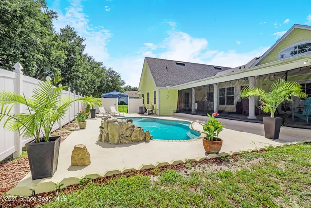 a view of a house with backyard and sitting area