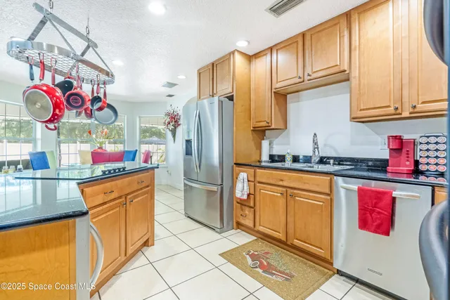 a kitchen with stainless steel appliances granite countertop a refrigerator and a stove top oven