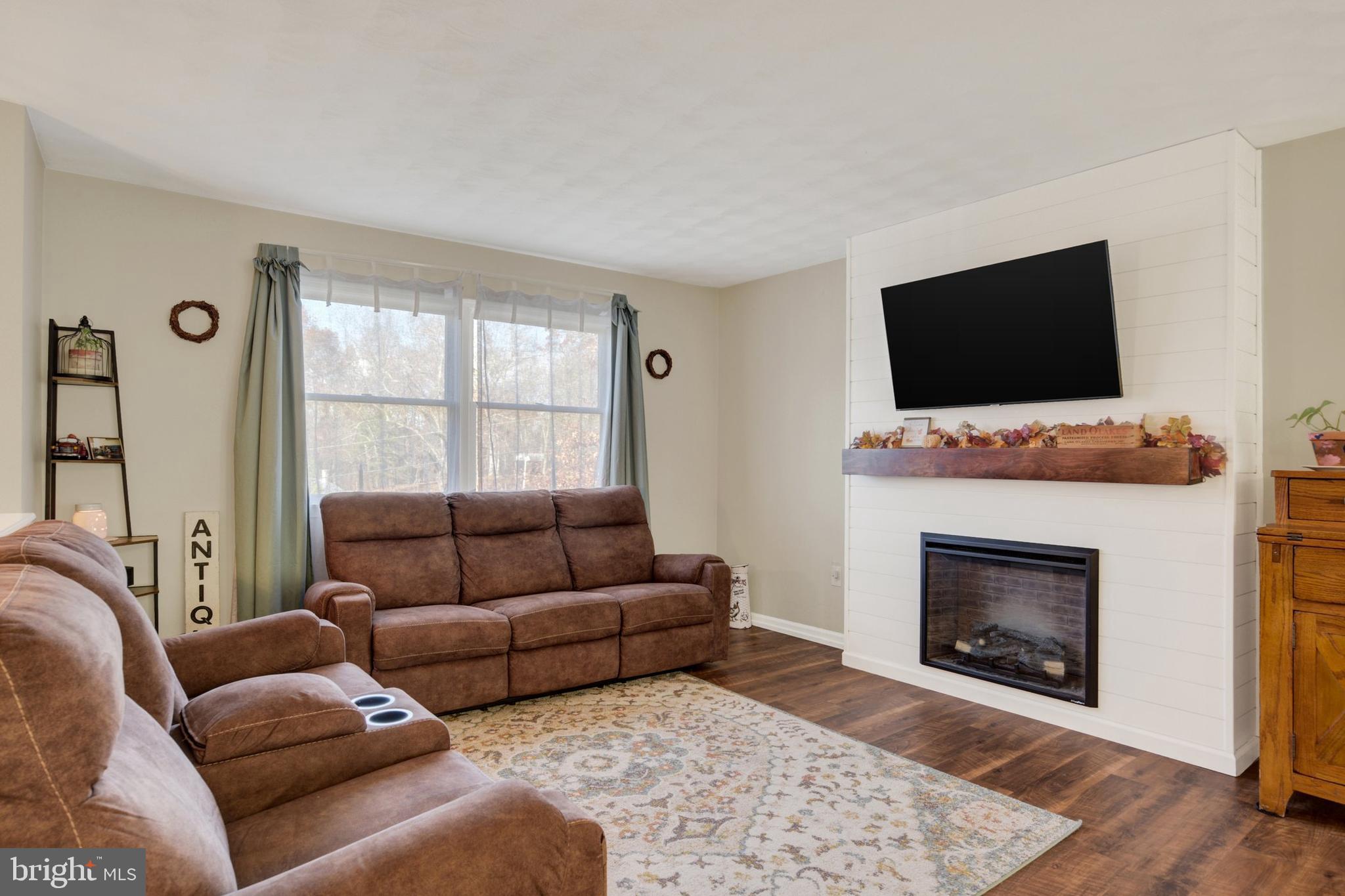 329 South Crawford Road Hummelstown, PA 17036 - Photo 3 of 17 a living room with furniture a flat screen tv and a fireplace