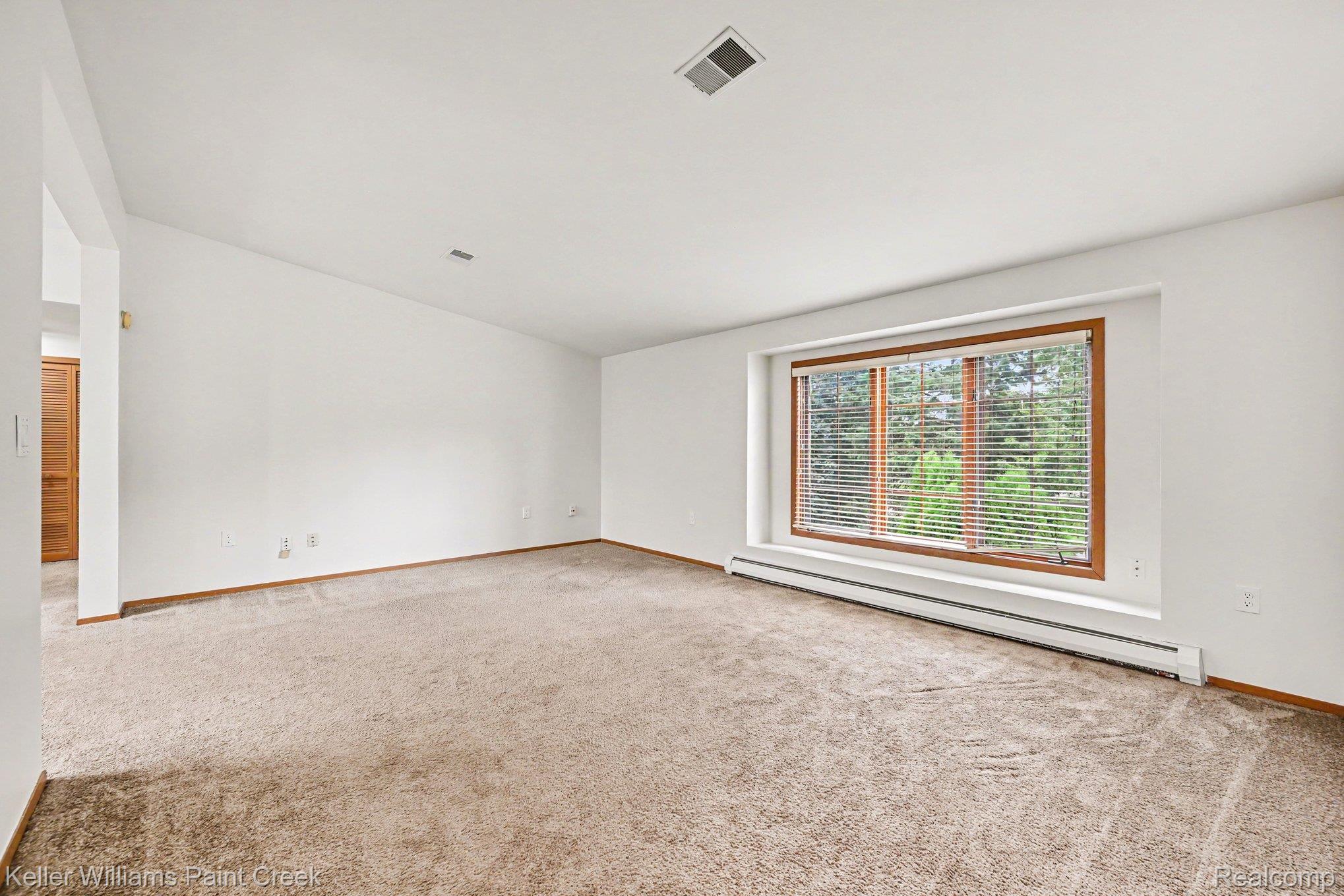 2232 London Bridge Drive Rochester, MI 48307 - Photo 5 of 26 Recessed window with wood trim, wall-to-wall carpeting, and baseboard heating