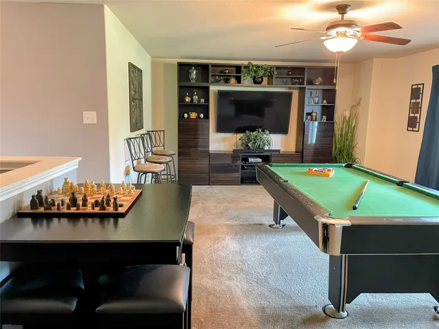 a room with pool table flat screen tv and windows