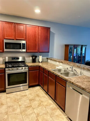 a kitchen with stainless steel appliances granite countertop a stove sink and microwave