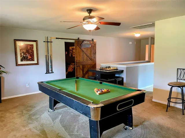 a room with pool table and windows