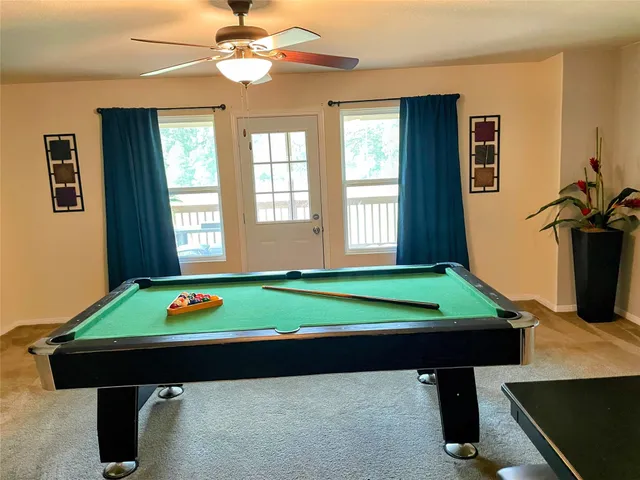 a room with pool table and windows