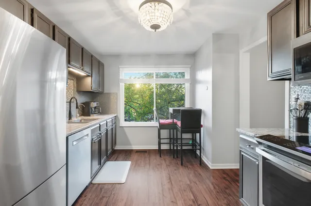 a kitchen with stainless steel appliances granite countertop a refrigerator and a sink