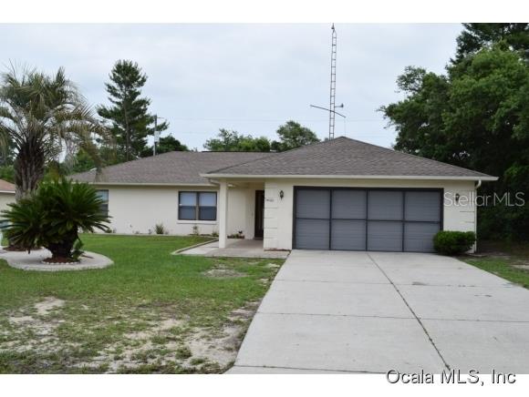 14095 Southwest 32nd Terrace Road Ocala, FL 34473 - Photo 1 of 1 a front view of a house with a yard and garage