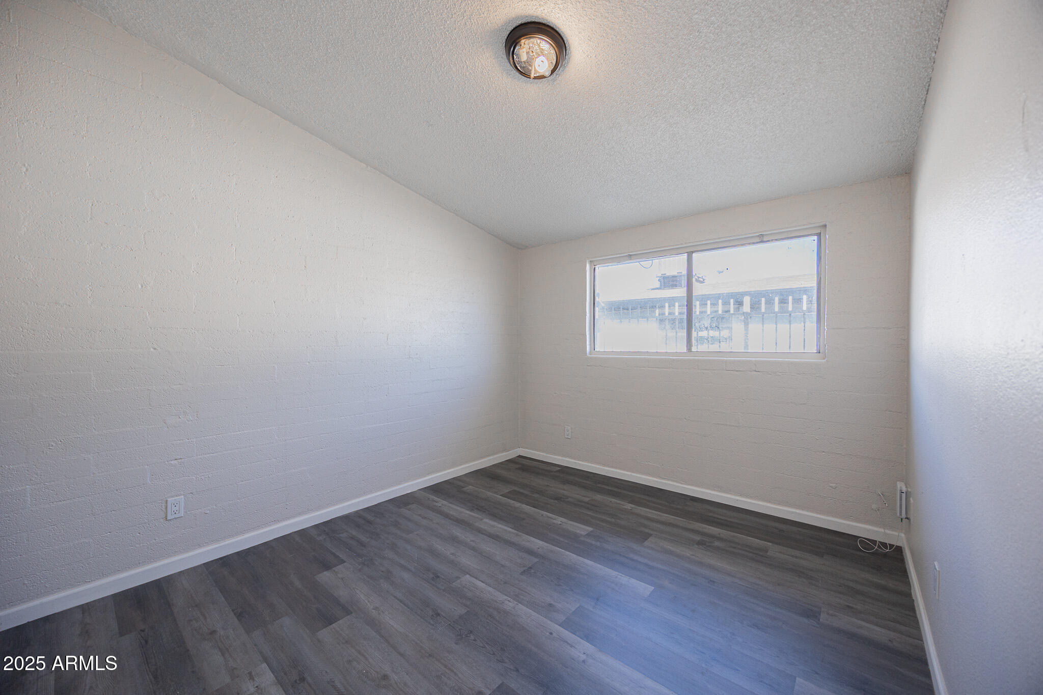 2123 West Devonshire Avenue, Unit 14 Phoenix, AZ 85015 - Photo 12 of 13 an empty room with wooden floor and windows