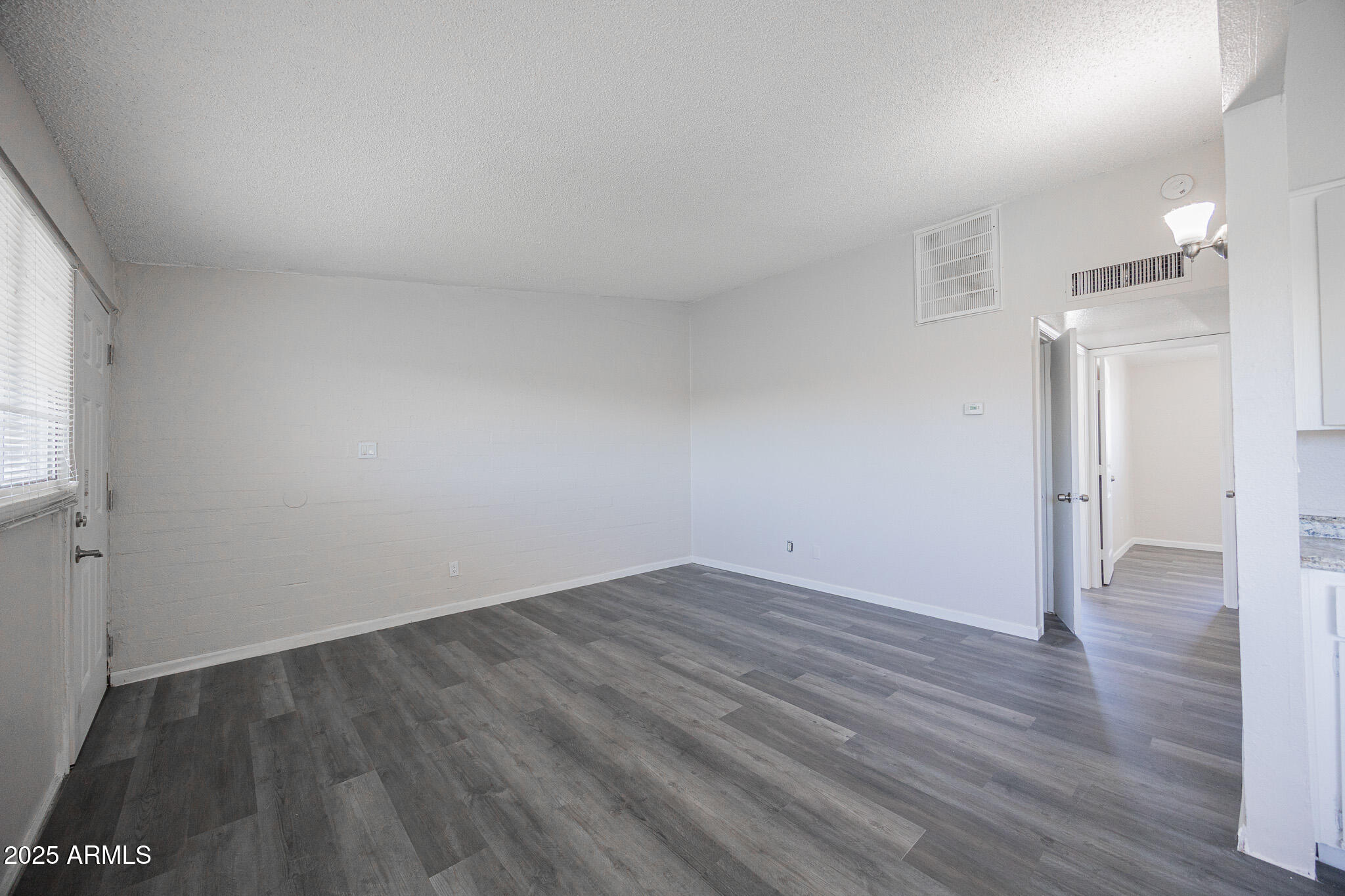 2123 West Devonshire Avenue, Unit 14 Phoenix, AZ 85015 - Photo 3 of 13 an empty room with wooden floor and windows