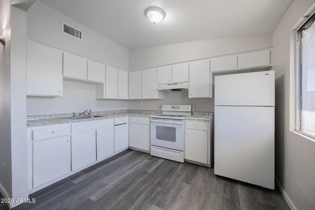 a kitchen with white cabinets and white appliances