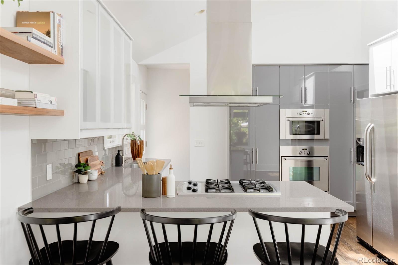 725 Monroe Street Denver, CO 80206 - Photo 11 of 33 a kitchen with stainless steel appliances granite countertop a stove a refrigerator a dining table and chairs
