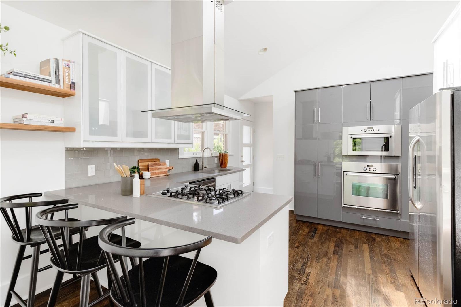 725 Monroe Street Denver, CO 80206 - Photo 12 of 33 a kitchen with stainless steel appliances granite countertop a kitchen island a stove a table and chairs