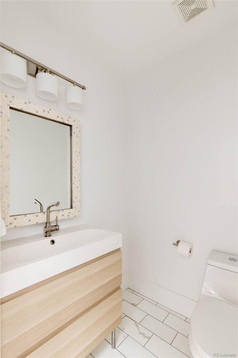 725 Monroe Street Denver, CO 80206 - Photo 15 of 33 a bathroom with a sink and a mirror