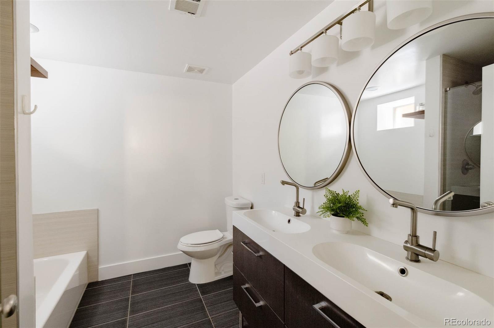725 Monroe Street Denver, CO 80206 - Photo 26 of 33 a bathroom with a sink a toilet and a mirror