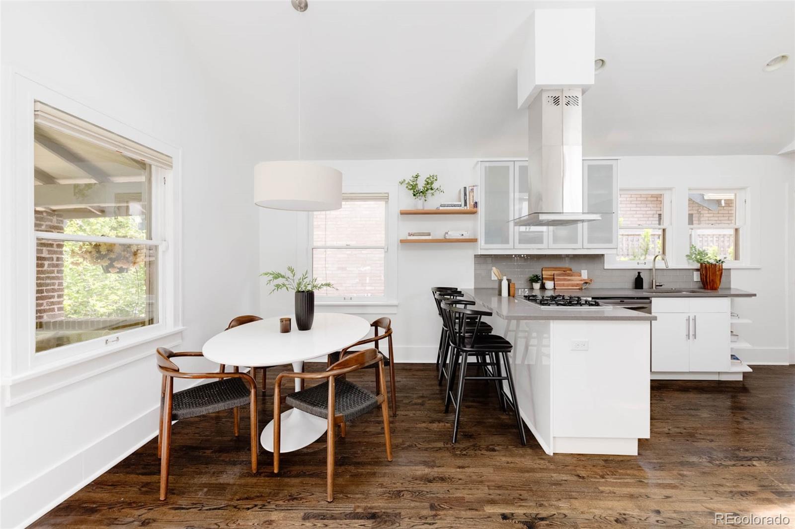 725 Monroe Street Denver, CO 80206 - Photo 9 of 33 a kitchen with a table chairs stove and white cabinets