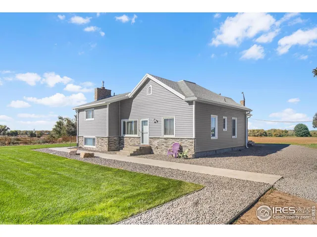 a front view of house with yard and trees in the background