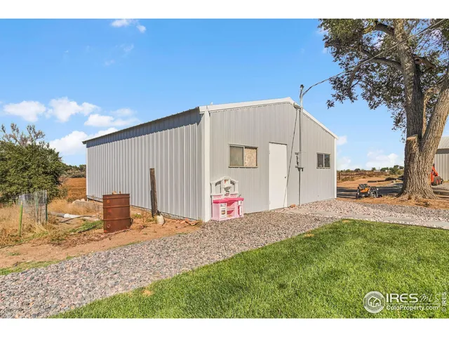 a view of a back yard with an tree and wooden fence