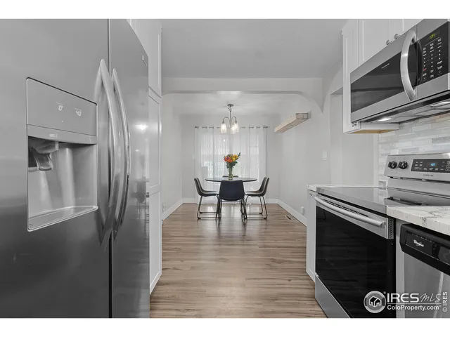 a open kitchen with stainless steel appliances granite countertop a refrigerator and a stove top oven