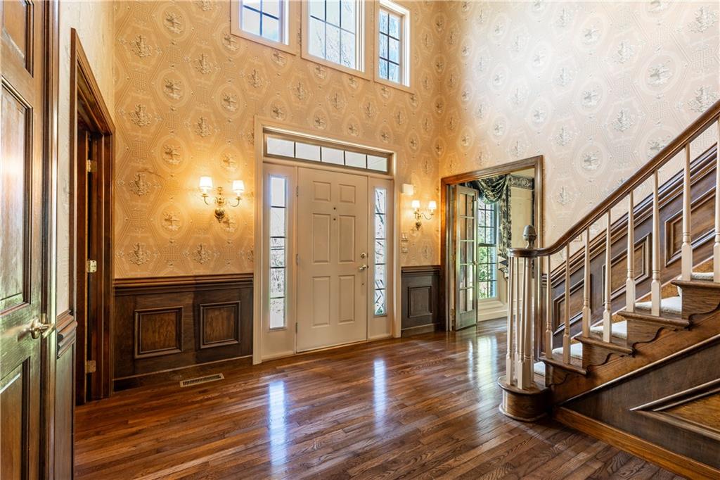 12"Crown Molding, Chair Rail with Wainscoting Detail, OverheadChandelier, 2 Wall Sconces Accenting Steel Front Door with SideLight Windows!