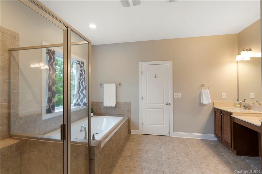 2011 Fallondale Road Waxhaw, NC 28173 - Photo 24 of 39 a bathroom with a tub a sink and mirrors