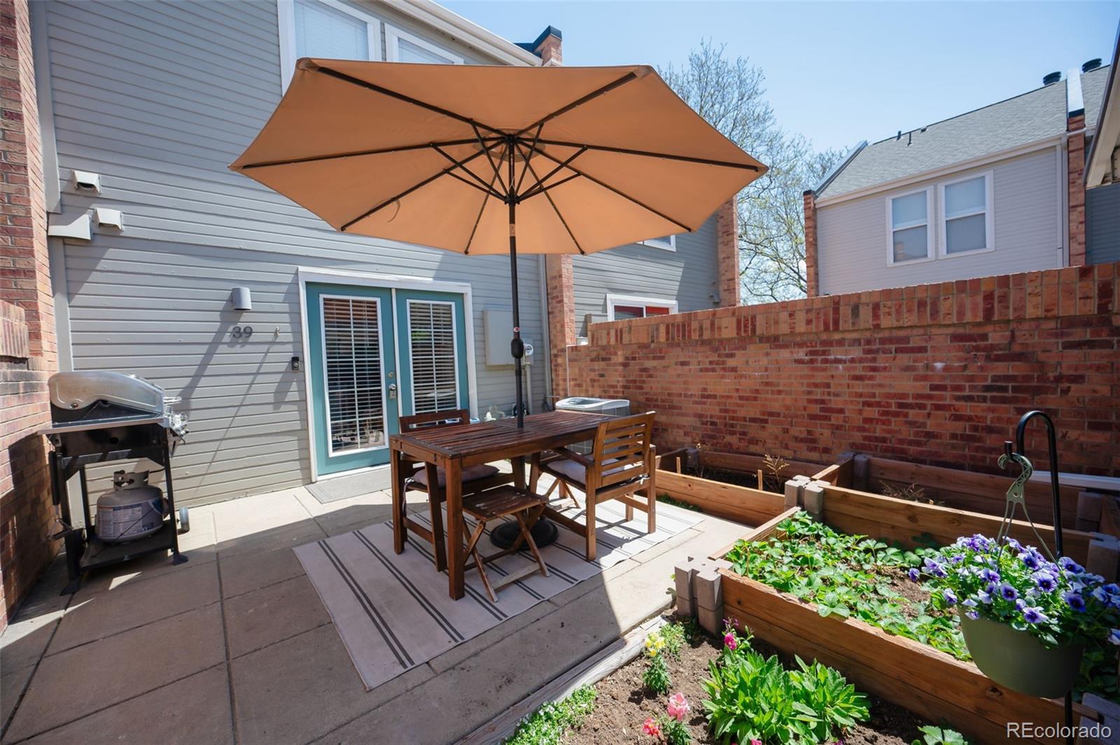 1150 Inca Street, Unit 39 Denver, CO 80204 - Photo 2 of 17 a view of a patio with table and chairs under an umbrella