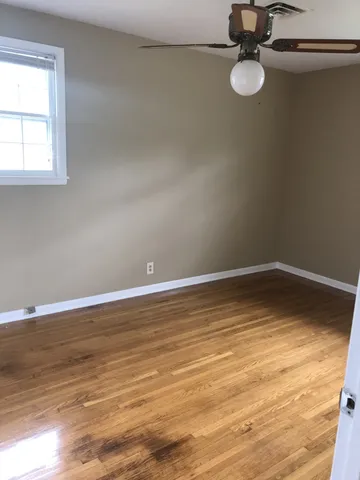 a view of a room with wooden floor and window