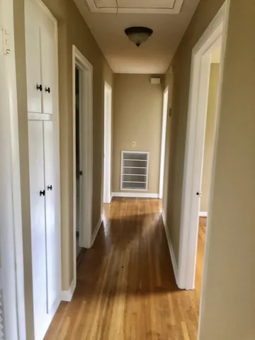 a view of a hallway with wooden floor and staircase