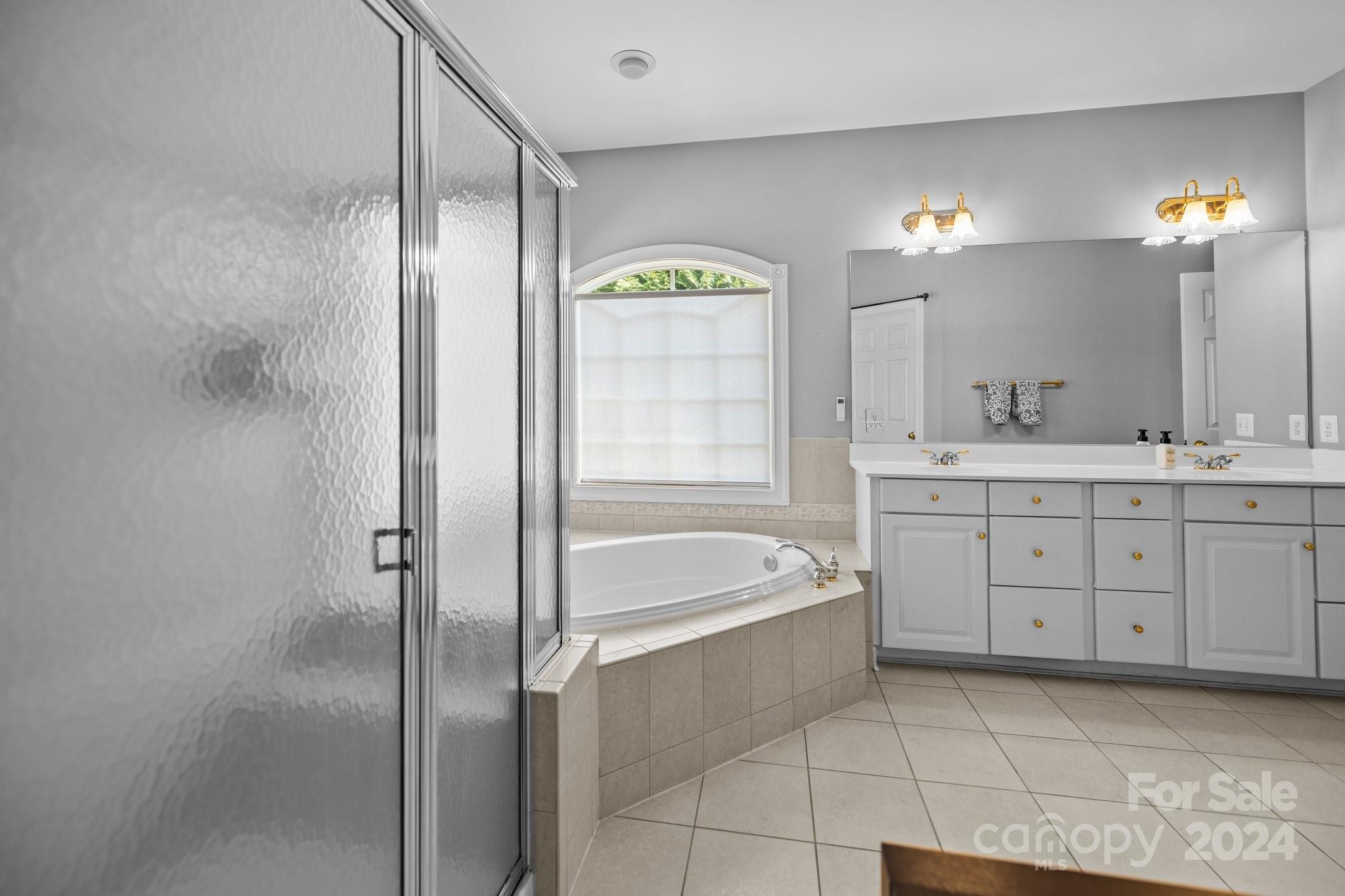 309 Chancelot Lane Fort Mill, SC 29708 - Photo 16 of 43 a spacious bathroom with a granite countertop sink a toilet a mirror a bathtub and shower