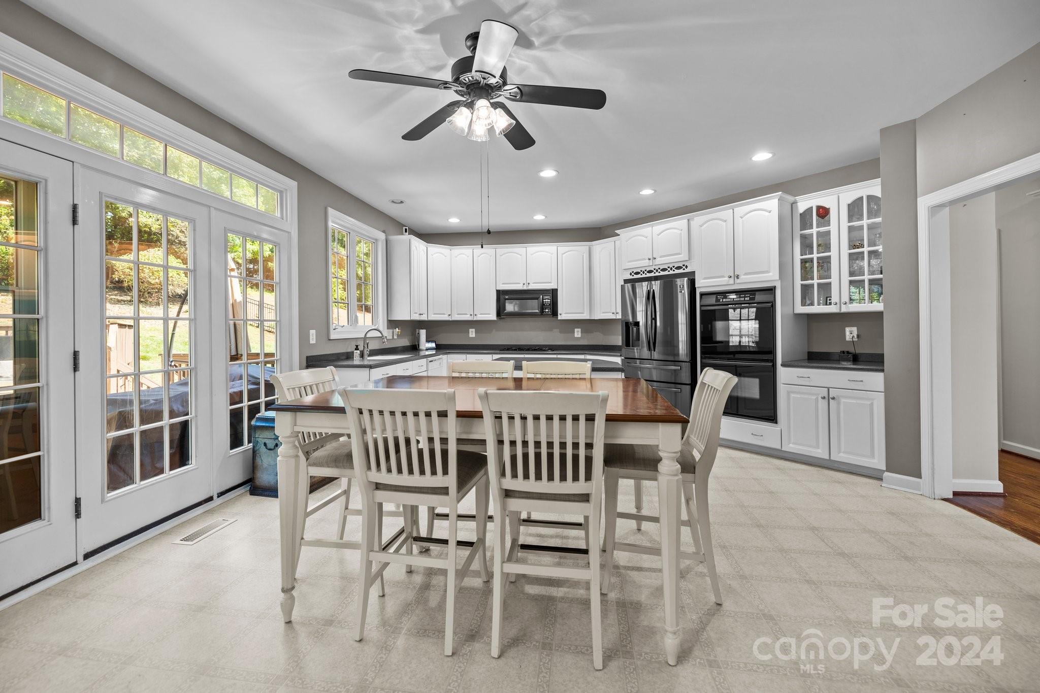 309 Chancelot Lane Fort Mill, SC 29708 - Photo 23 of 43 a kitchen with stainless steel appliances kitchen island granite countertop a dining table chairs refrigerator and cabinets