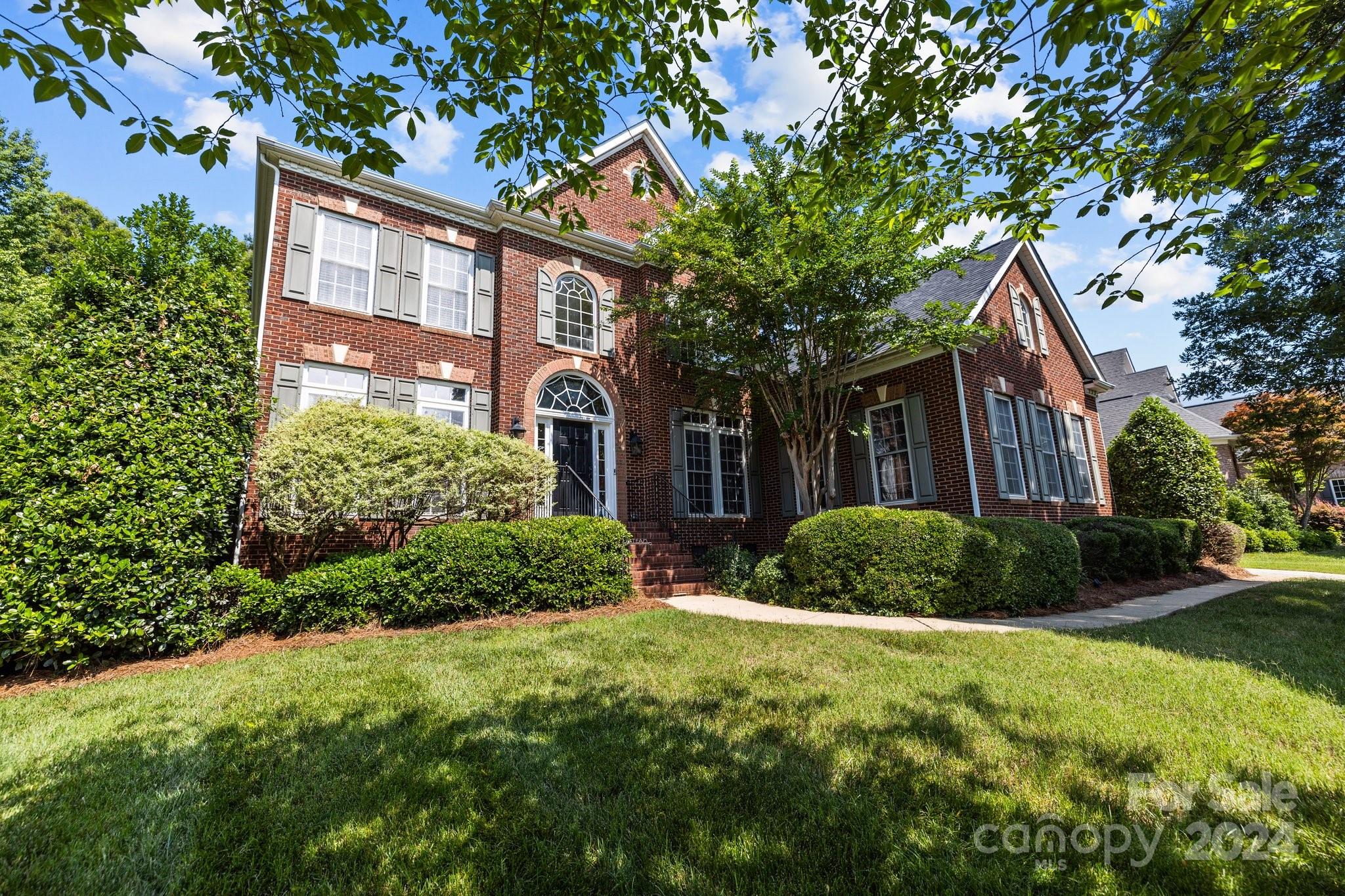 309 Chancelot Lane Fort Mill, SC 29708 - Photo 3 of 43 a view of a brick house with a yard and large trees