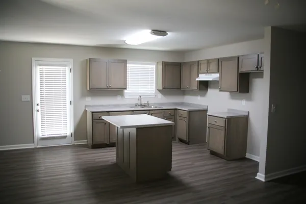a kitchen with a sink cabinets and wooden floor