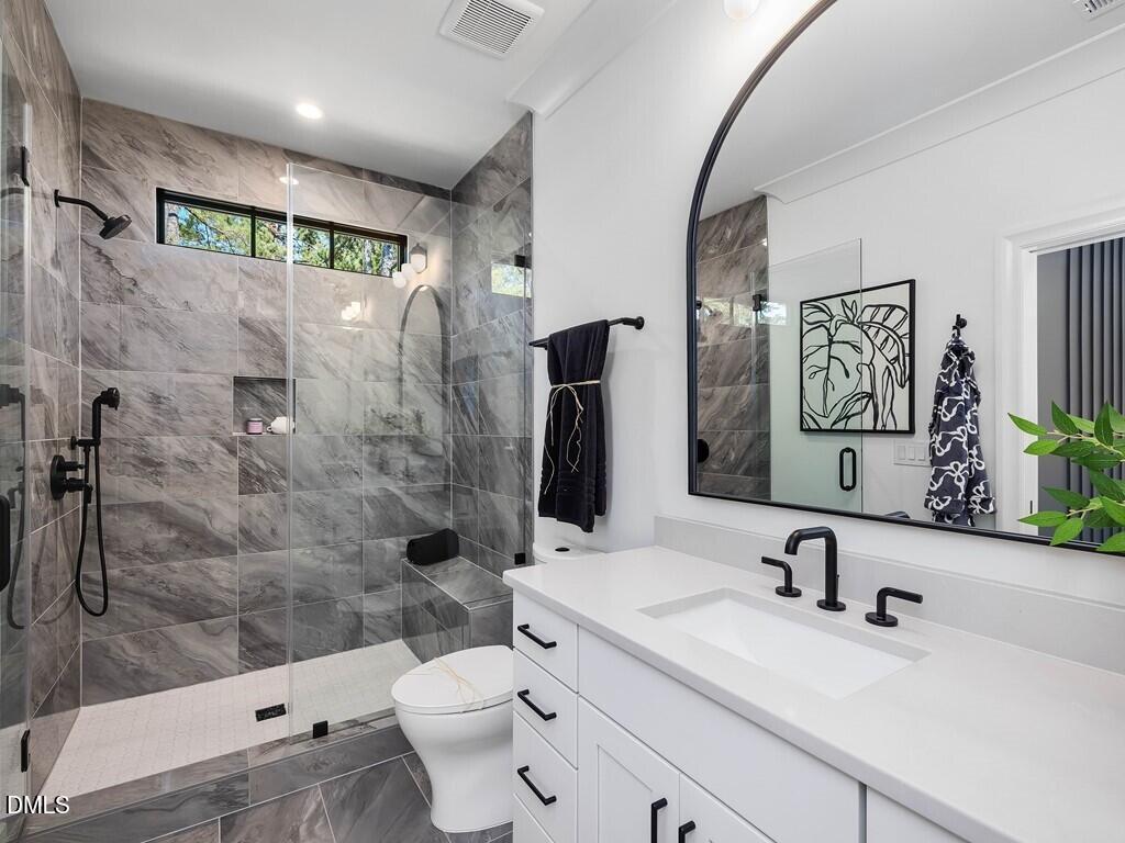 7013 Buckhead Drive Raleigh, NC 27615 - Photo 50 of 80 a bathroom with a sink a toilet and shower