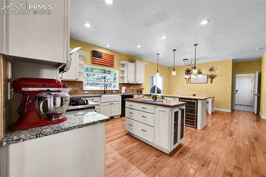 16540 Mesquite Road Peyton, CO 80831 - Photo 16 of 50 a kitchen with stainless steel appliances granite countertop a stove and a wooden floors