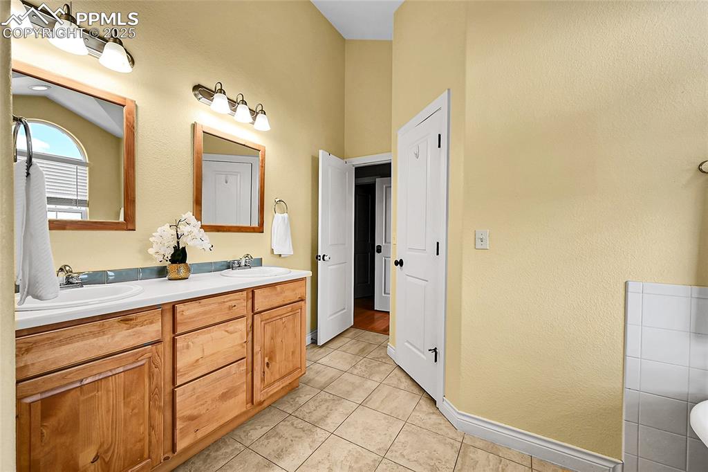 16540 Mesquite Road Peyton, CO 80831 - Photo 27 of 50 a spacious bathroom with a double vanity sink and a mirror