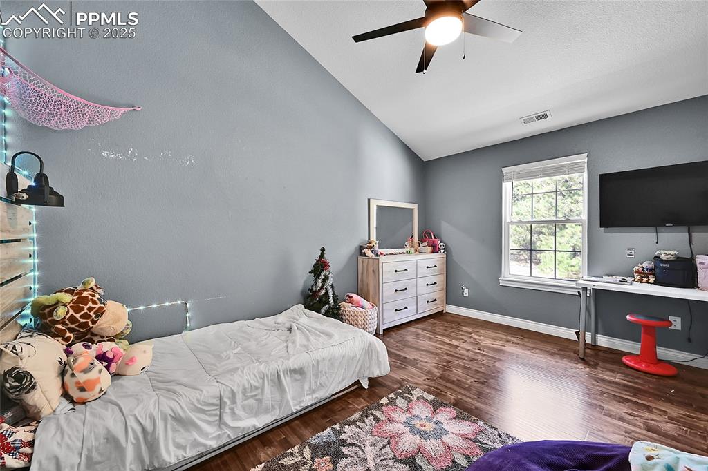 16540 Mesquite Road Peyton, CO 80831 - Photo 28 of 50 a bedroom with a bed and a flat screen tv