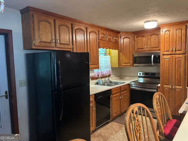 a kitchen with stainless steel appliances granite countertop a refrigerator and a stove top oven