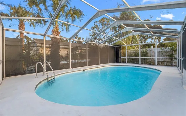 a view of a swimming pool with a porch and furniture