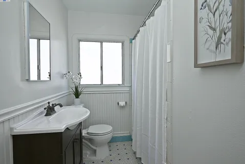 a bathroom with a granite countertop sink a toilet and a mirror