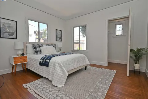 a bedroom with a large bed and wooden floor