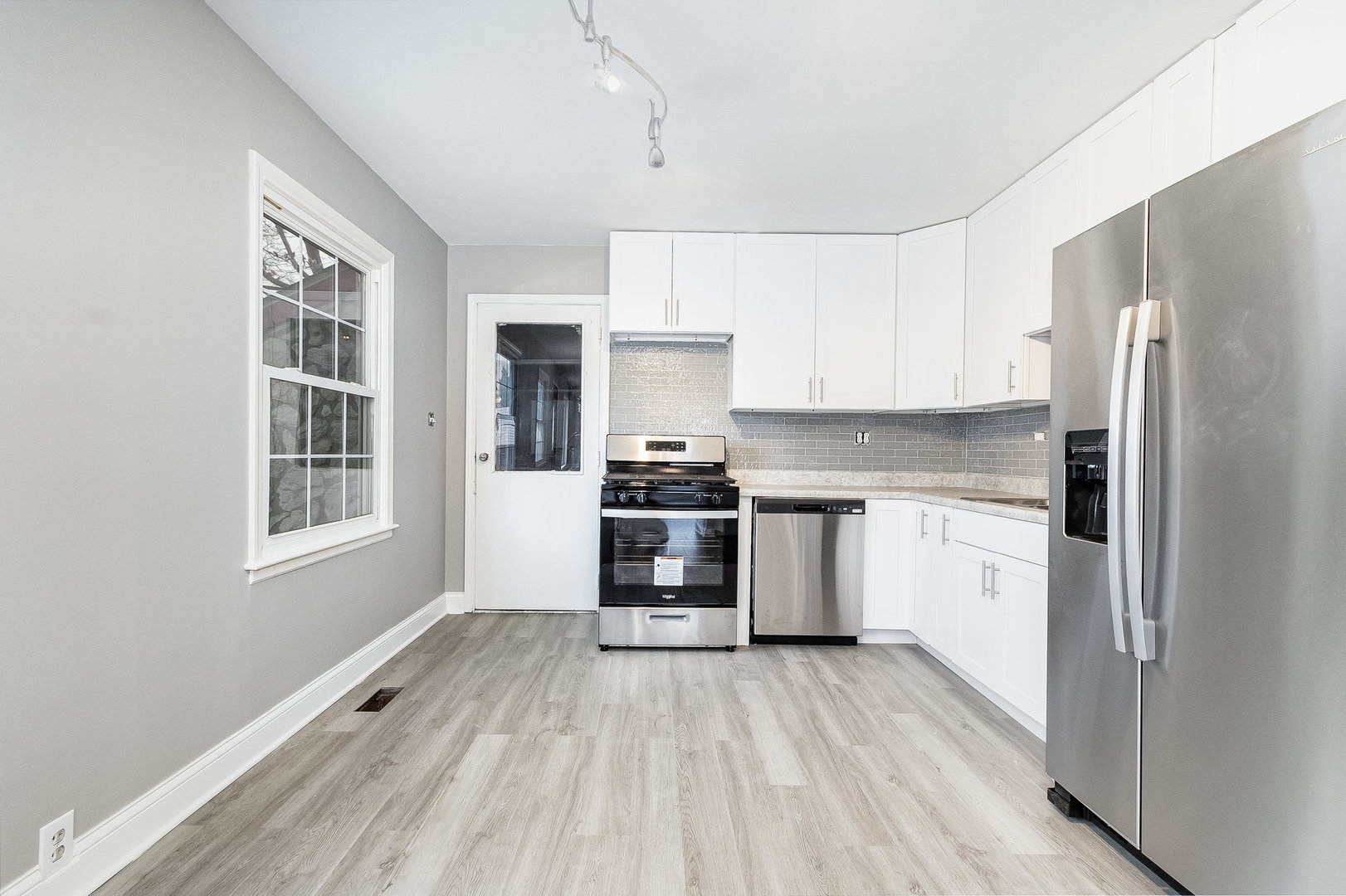 626 Iola Avenue Romeoville, IL 60446 - Photo 4 of 19 a kitchen with granite countertop a refrigerator oven a sink dishwasher and white cabinets with wooden floor