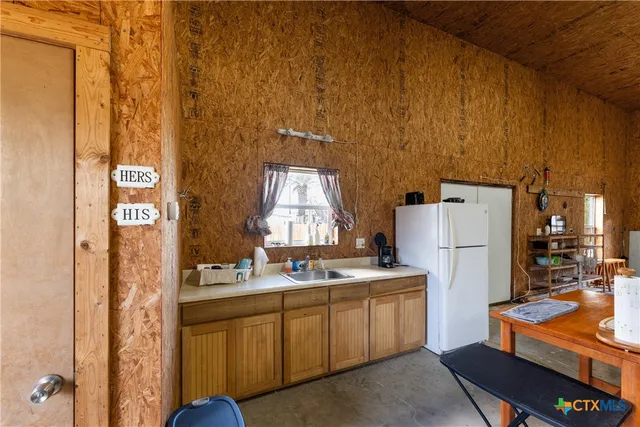 a kitchen with stainless steel appliances a refrigerator and a stove top oven