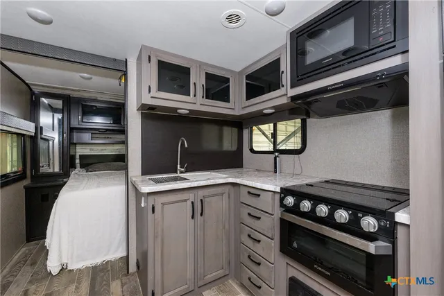 a kitchen with stainless steel appliances a stove a refrigerator and a microwave