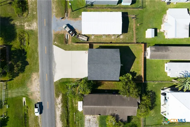 an aerial view of residential houses with outdoor space and parking