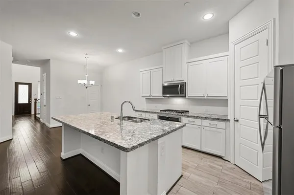 a kitchen with stainless steel appliances granite countertop a sink stove and refrigerator