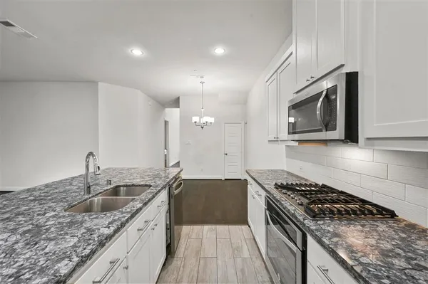 a kitchen with a sink stove top oven and cabinets