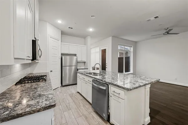 a kitchen with stainless steel appliances granite countertop a sink stove and refrigerator