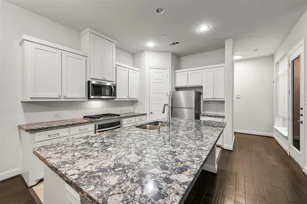a kitchen with stainless steel appliances granite countertop a sink stove and refrigerator