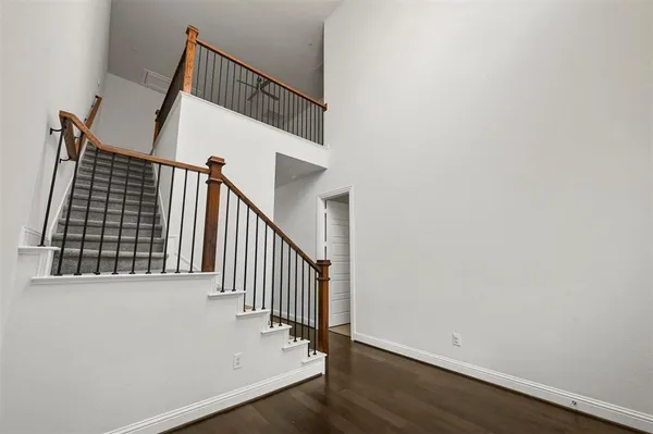 a view of staircase with wooden floor and white walls